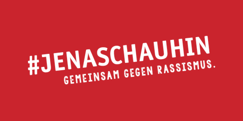 Der Schriftzug #JenaSchauHin, gemeinsam gegen Rassismus in weißer Schrift auf roten Grund