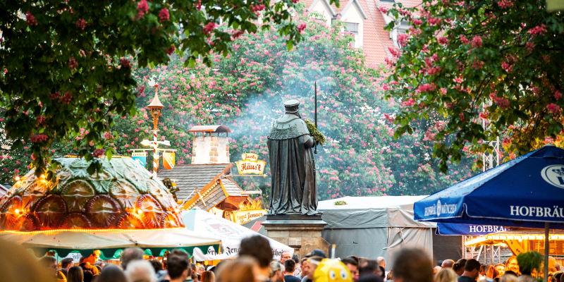 Gäste des Jenaer Frühlingsmarktes auf dem Marktplatz vor der Hanfried-Statue und Ständen des Stadtfestes